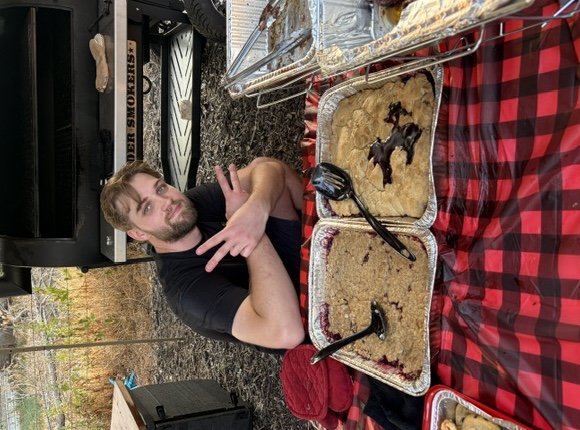 Tyler Nelson with desserts beside a smoker